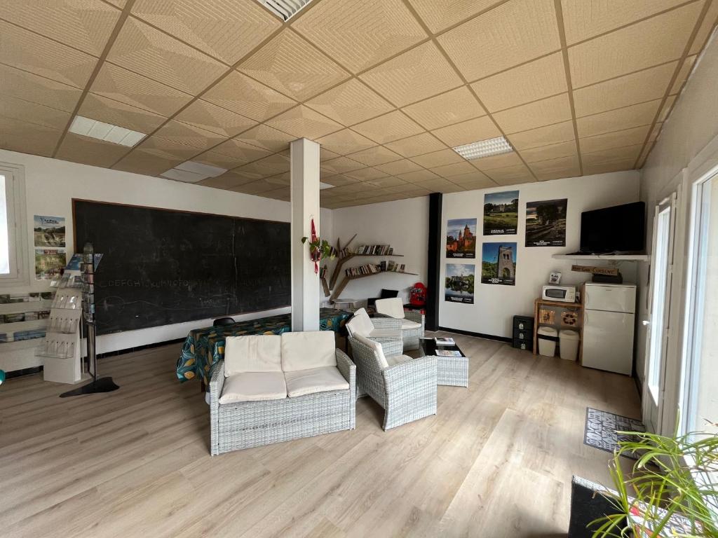 Elle comprend un salon doté d'un mobilier blanc et d'un tableau noir. dans l'établissement Camping du Lac, à Marcillac-la-Croisille