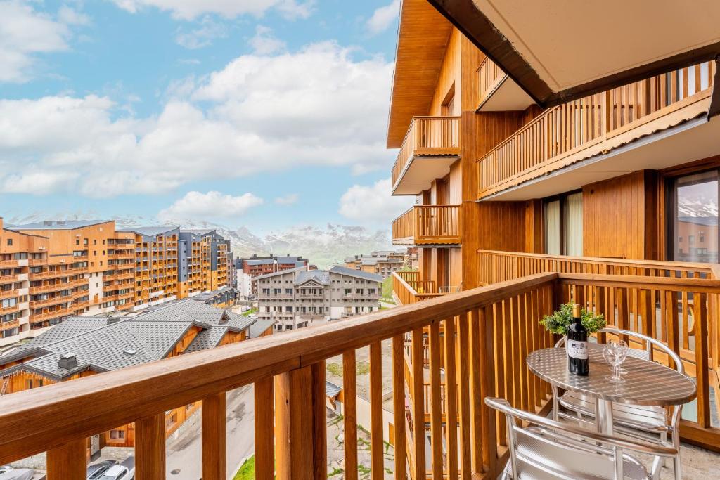 un balcon avec une table et des chaises et une vue dans l'établissement Ski In-Out - Heart of Val Thorens Warm-Hearted Apartment, WiFi 165, à Val Thorens