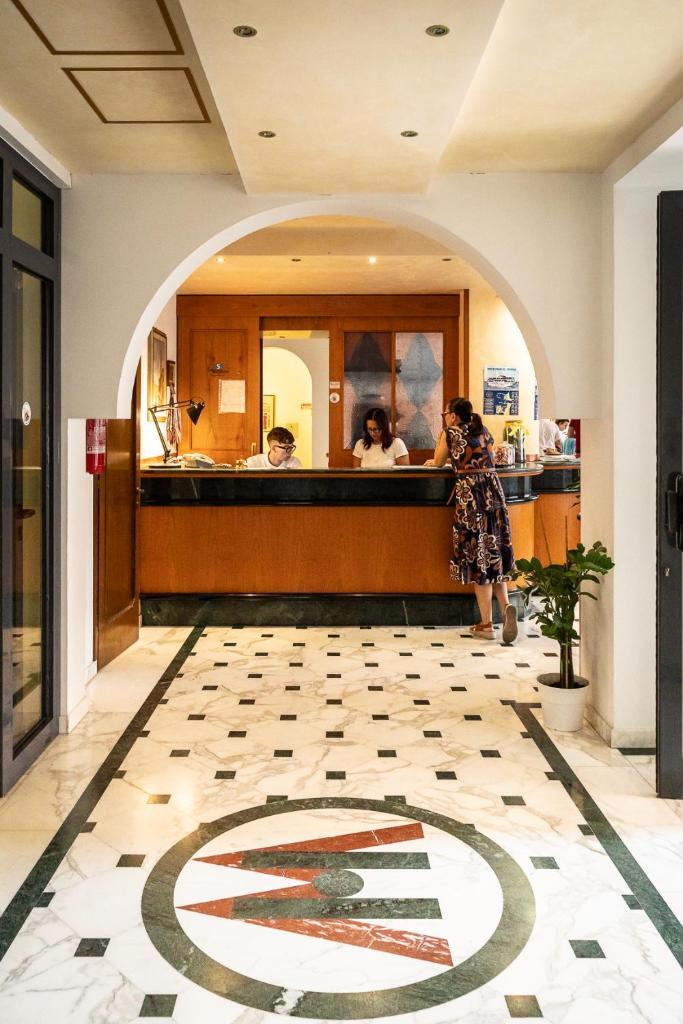 une femme debout au comptoir d'un restaurant dans l'établissement Easy Hotel Meryon, à Sottomarina