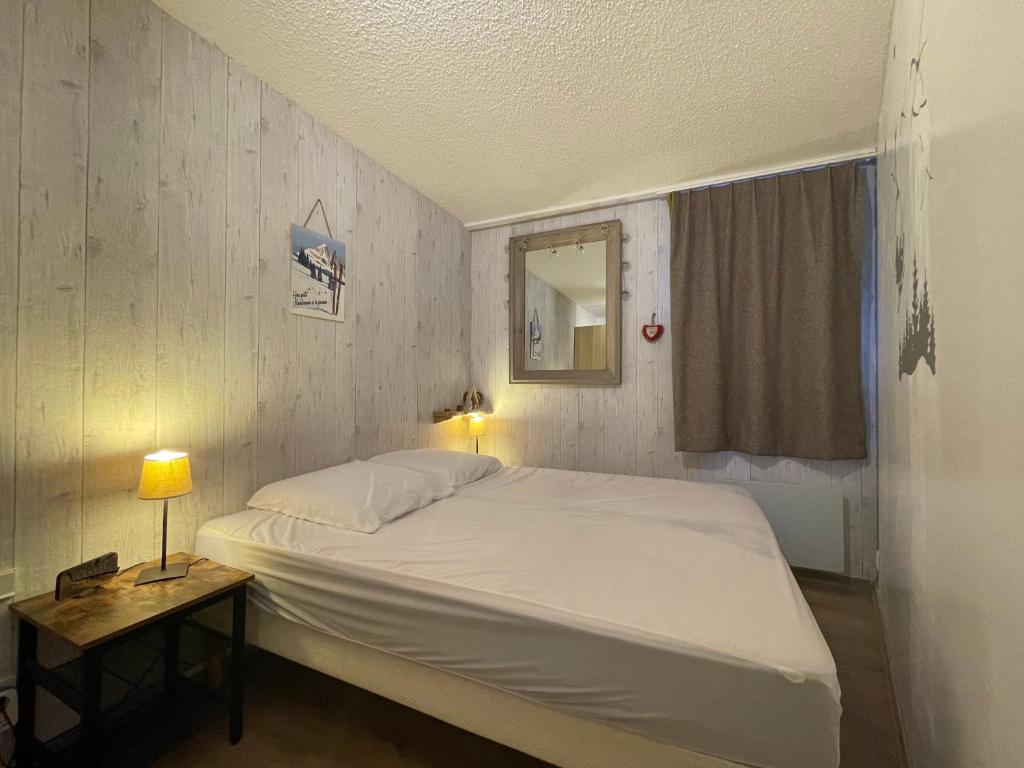 une chambre avec un grand lit blanc et un miroir dans l'établissement Homency - Résidence aux Bergers B502, à L'Alpe-d'Huez