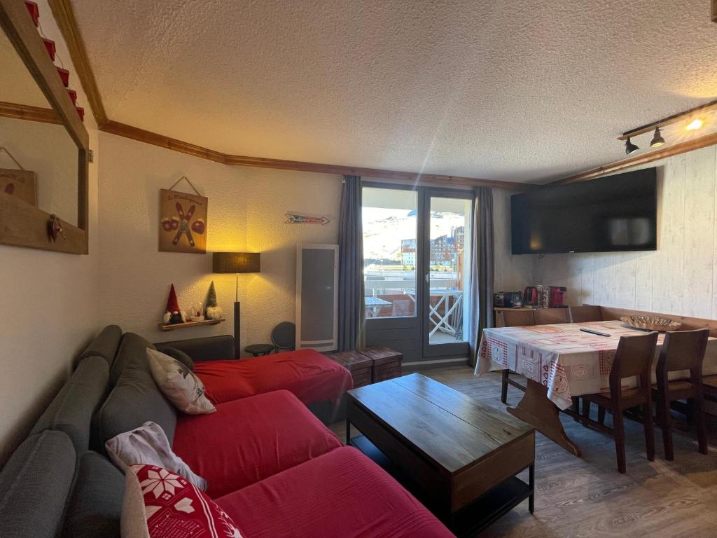 un salon avec un canapé rouge et une table dans l'établissement Homency - Résidence aux Bergers B502, à L'Alpe-d'Huez