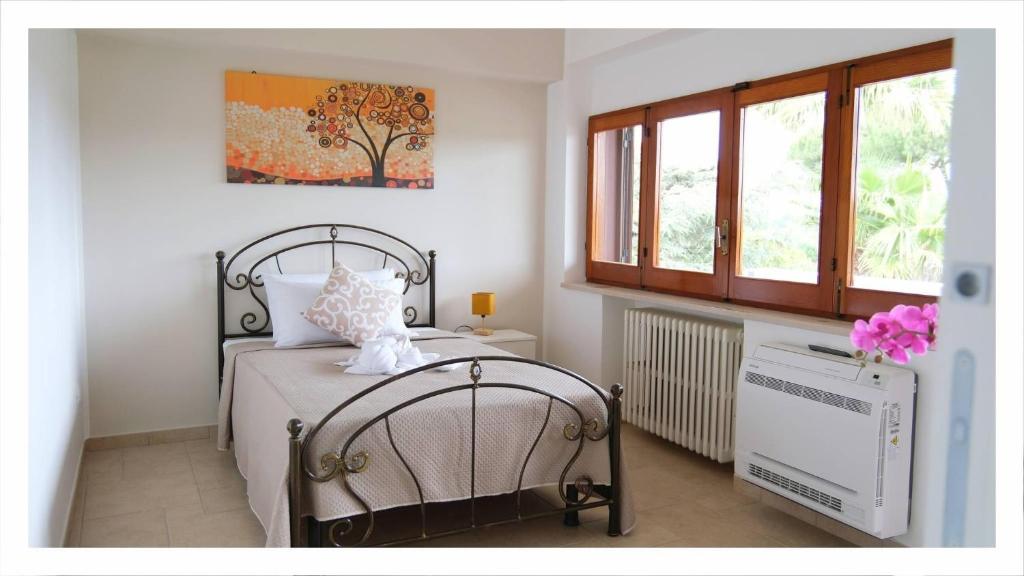 - une chambre avec un lit, un radiateur et des fenêtres dans l'établissement Antica Foggia Vetere villa con piscina, à Ceglie Messapica