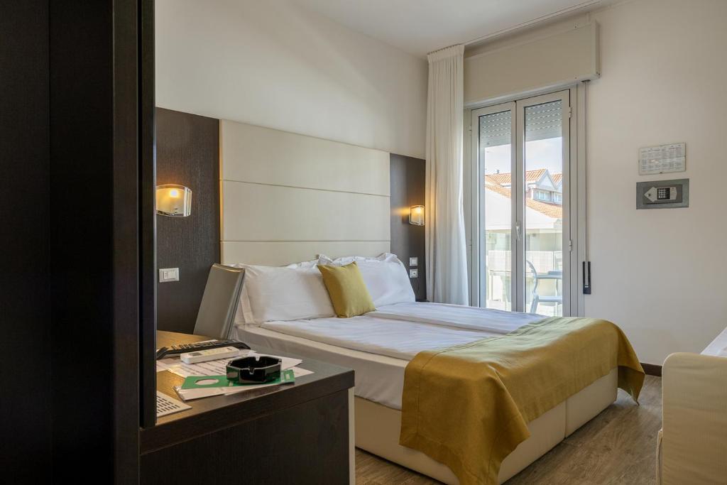 une chambre d'hôtel avec un lit et une table dans l'établissement Hotel Bristol, à Caorle