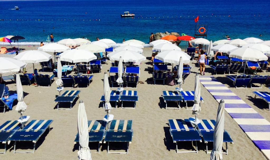 - un bouquet de chaises et de parasols sur une plage dans l'établissement Villa Chiara Taormina, à Taormine