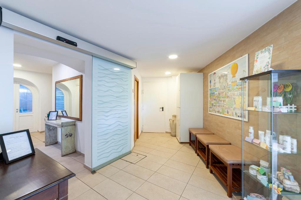 un couloir dans un bâtiment doté de bancs et d'un comptoir dans l'établissement Hotel Gran Paradiso, à Ischia