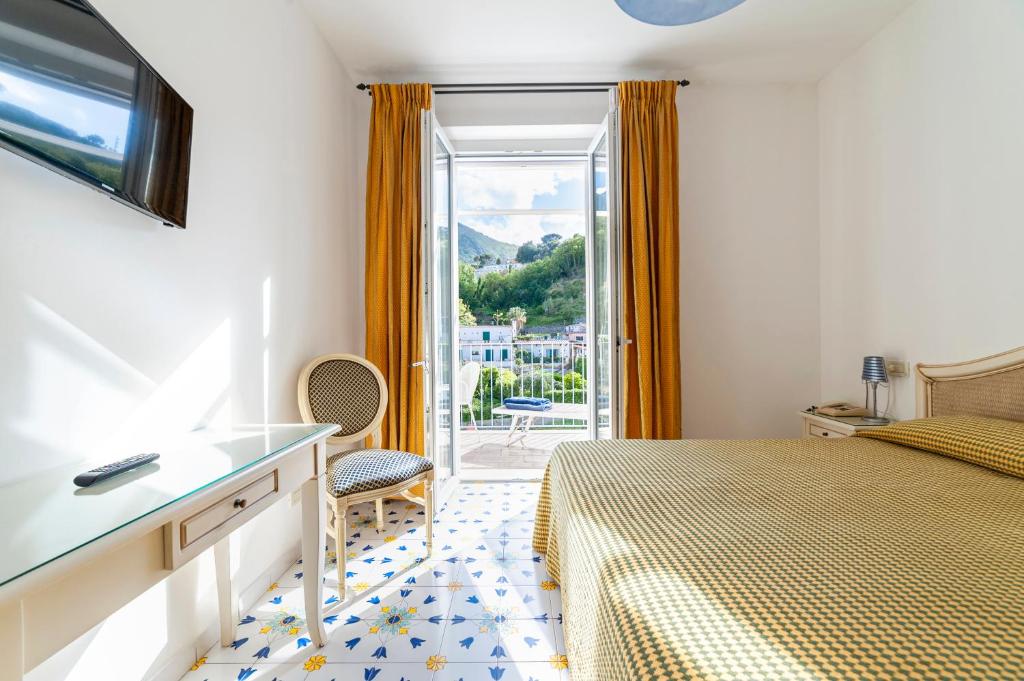 une chambre d'hôtel avec un lit et un balcon dans l'établissement Hotel Gran Paradiso, à Ischia