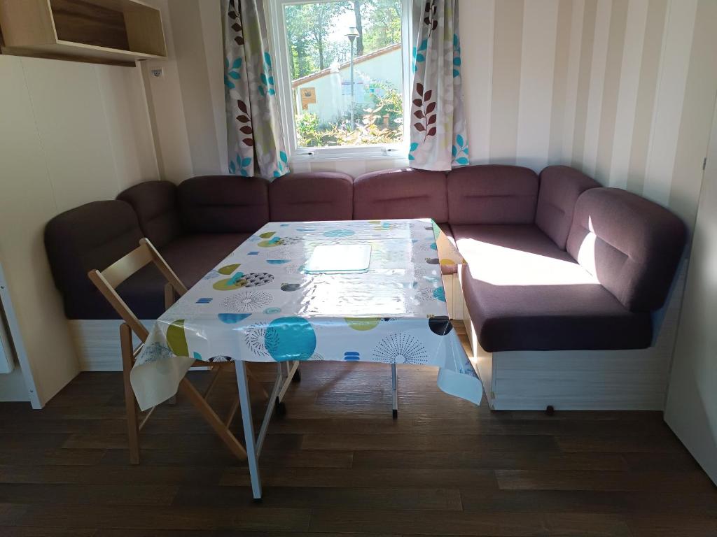 un salon avec un canapé et une table dans l'établissement Mobil-home en pleine Nature, à La Boissière-de-Montaigu