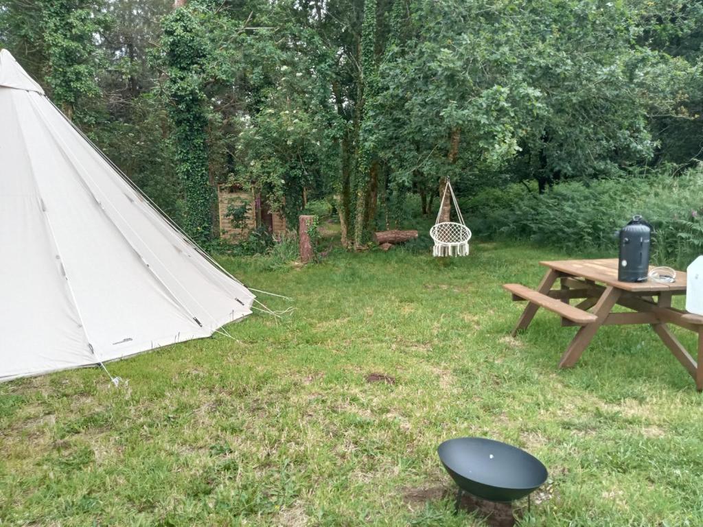 - une tente et une table de pique-nique dans la cour dans l'établissement tipi insolite 1 a 4 personnes, à Plouray