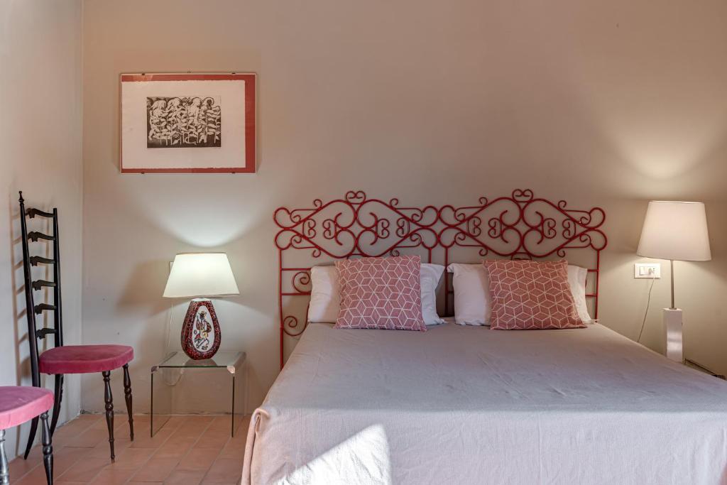 une chambre avec un grand lit avec des oreillers roses dans l'établissement Villa San Giuseppe Scirocco, à Montecatini Val di Cecina