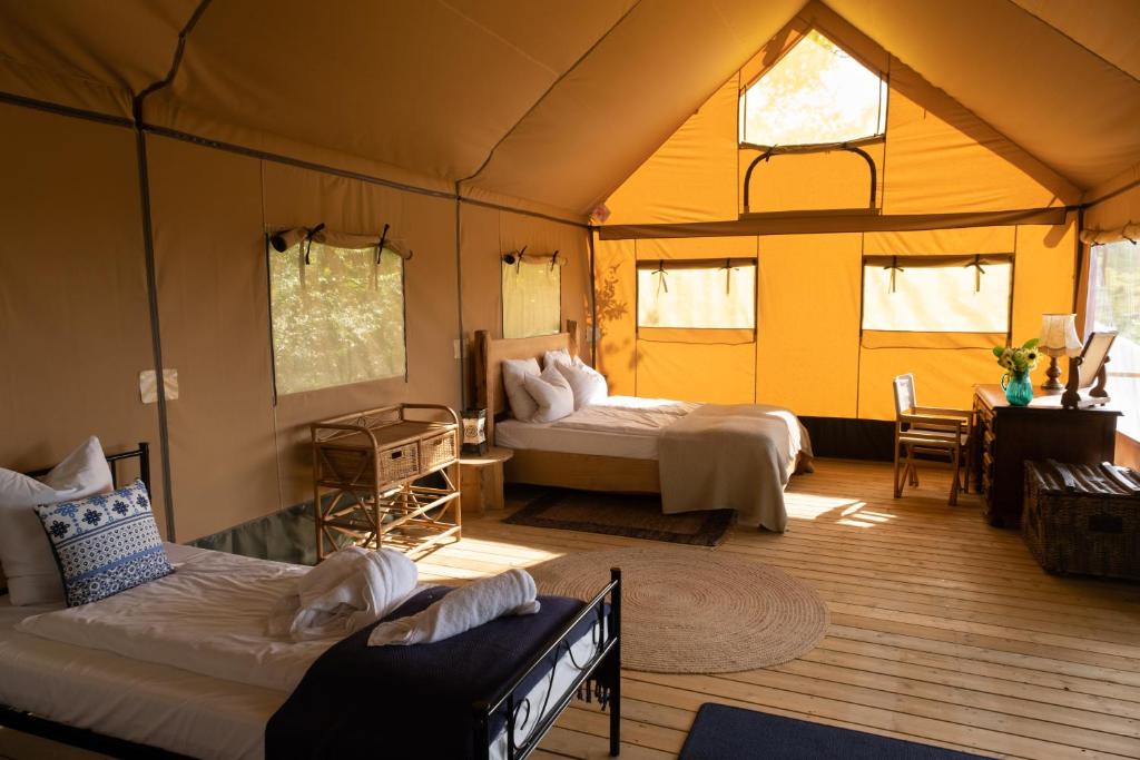 une chambre avec deux lits dans une tente dans l'établissement Le Camp, à Varen