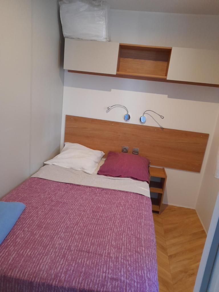 - une petite chambre avec un lit et une couverture violette dans l'établissement Camping del Mar 15, Mobile Home Excellence 6 personnes, 3 chambres, 40 m2, à Argelès-sur-Mer