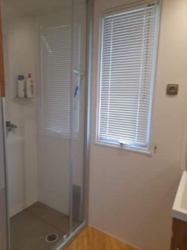 La salle de bains est pourvue d'une douche et d'une fenêtre. dans l'établissement Camping del Mar 15, Mobile Home Excellence 6 personnes, 3 chambres, 40 m2, à Argelès-sur-Mer