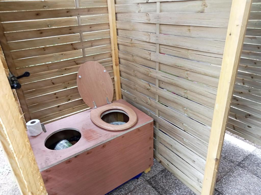 des toilettes avec un siège de toilette dans une cabine en bois dans l'établissement tipi insolite 1 a 4 personnes, à Plouray