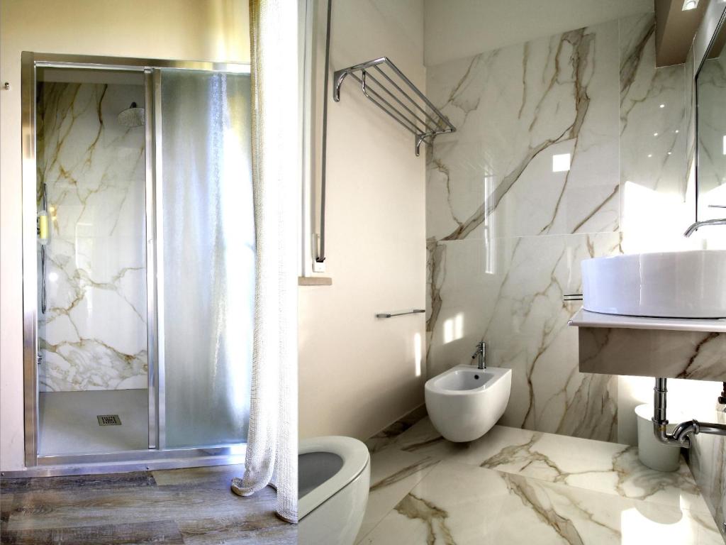 une salle de bain avec une douche, des toilettes et un lavabo dans l'établissement Hotel Fabrizio, à Rimini