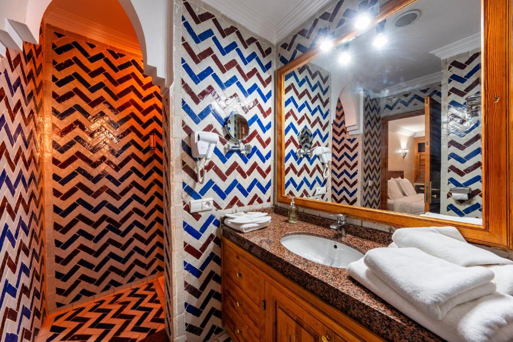 une salle de bain avec un lavabo et un miroir dans l'établissement Suites & Spa BY XO-RIAD, à Marrakech 37 autres photos