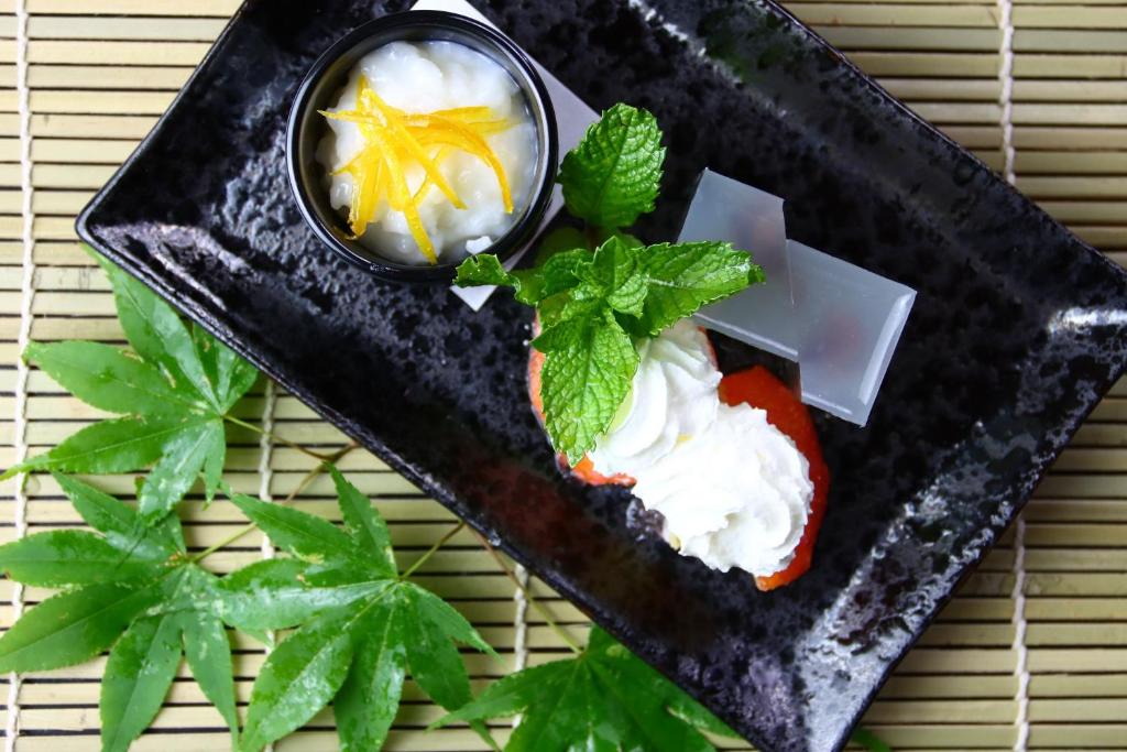 une assiette de nourriture avec de la crème fouettée et de la menthe dans l'établissement Baigetsu Ryokan, à Shimo-suwa