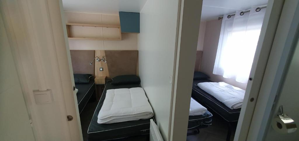 une petite chambre avec deux lits et une fenêtre dans l'établissement MH 3ch calme Bois Dormant accueil personnalisé, à Saint-Jean-de-Monts 37 autres photos