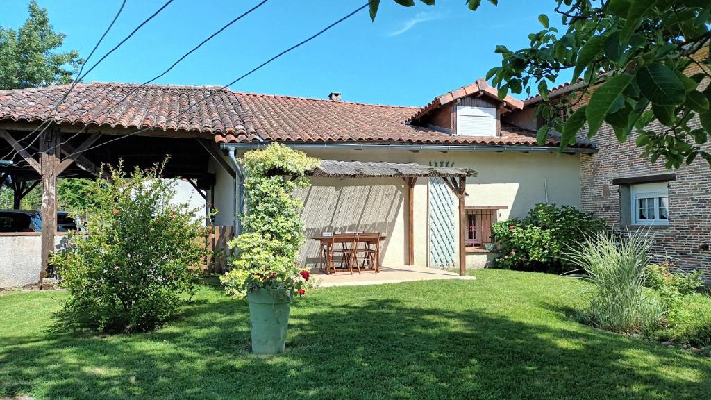 Cette maison dispose d'une terrasse et d'une table dans la cour. dans l'établissement Gîte d'en Pouillac, à Saint-Thomas