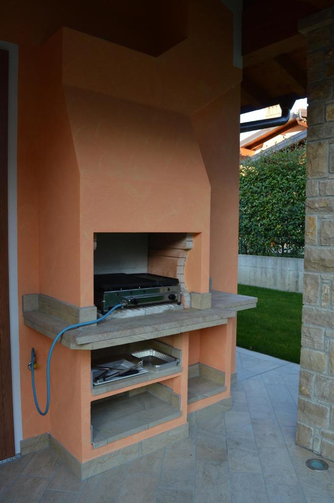 d'une cheminée dans une terrasse avec un mur orange. dans l'établissement Villa Artemia, à Manerba del Garda