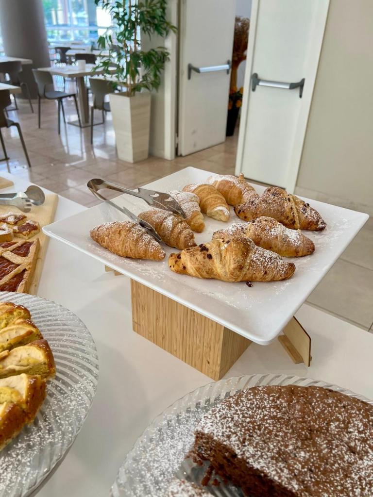 une table surmontée de plateaux de pâtisseries et de pains dans l'établissement Hotel Vernel, à Rimini