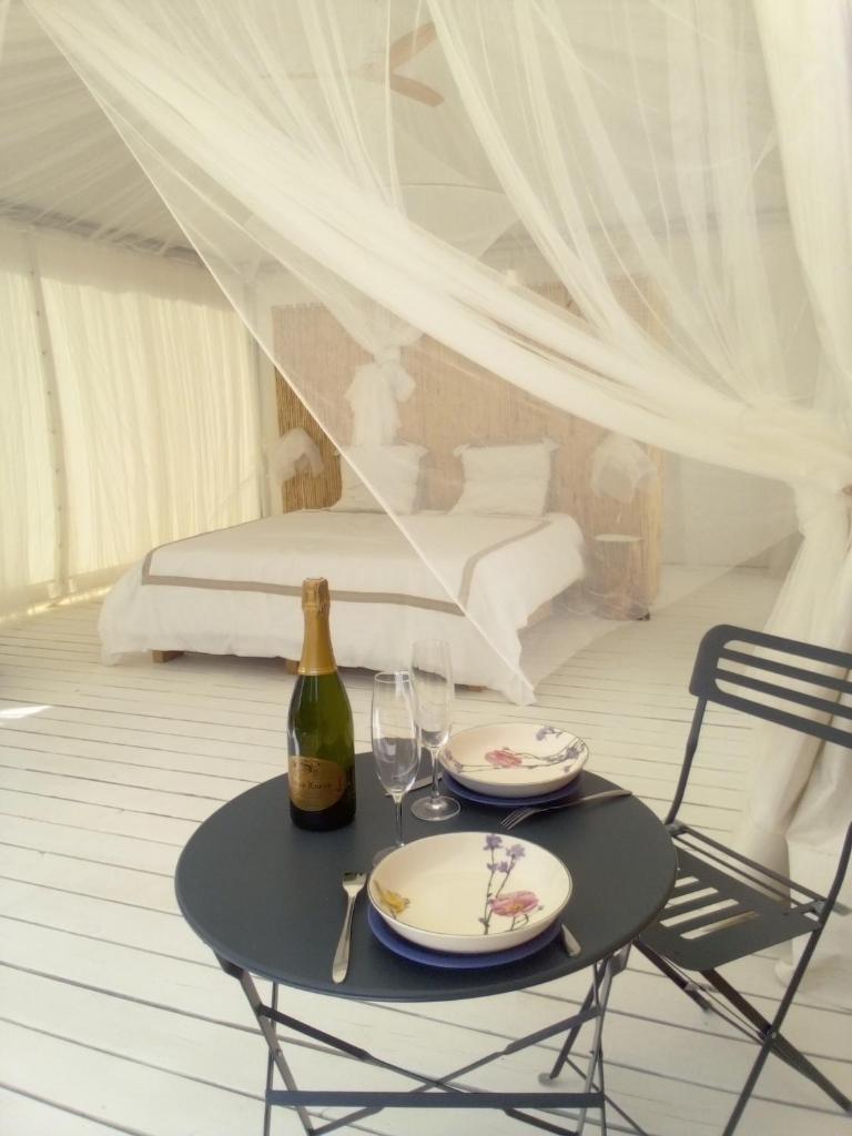- une table avec 2 verres et une bouteille de vin dans l'établissement Glamping at Séraphin's, à Navacelles