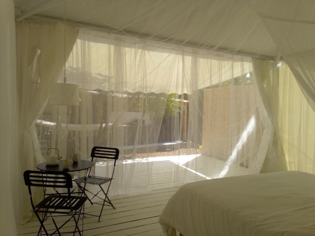 une chambre avec un lit, une table et des chaises dans l'établissement Glamping at Séraphin's, à Navacelles