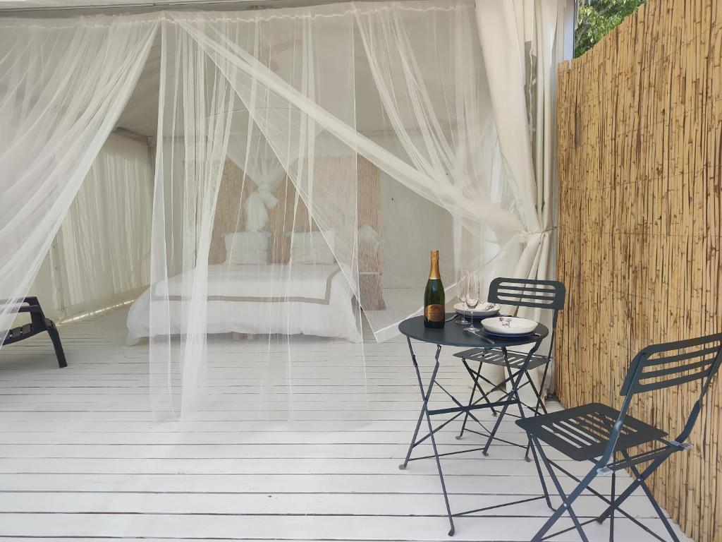 un patio avec une table, des chaises et un lit dans l'établissement Glamping at Séraphin's, à Navacelles 10 autres photos