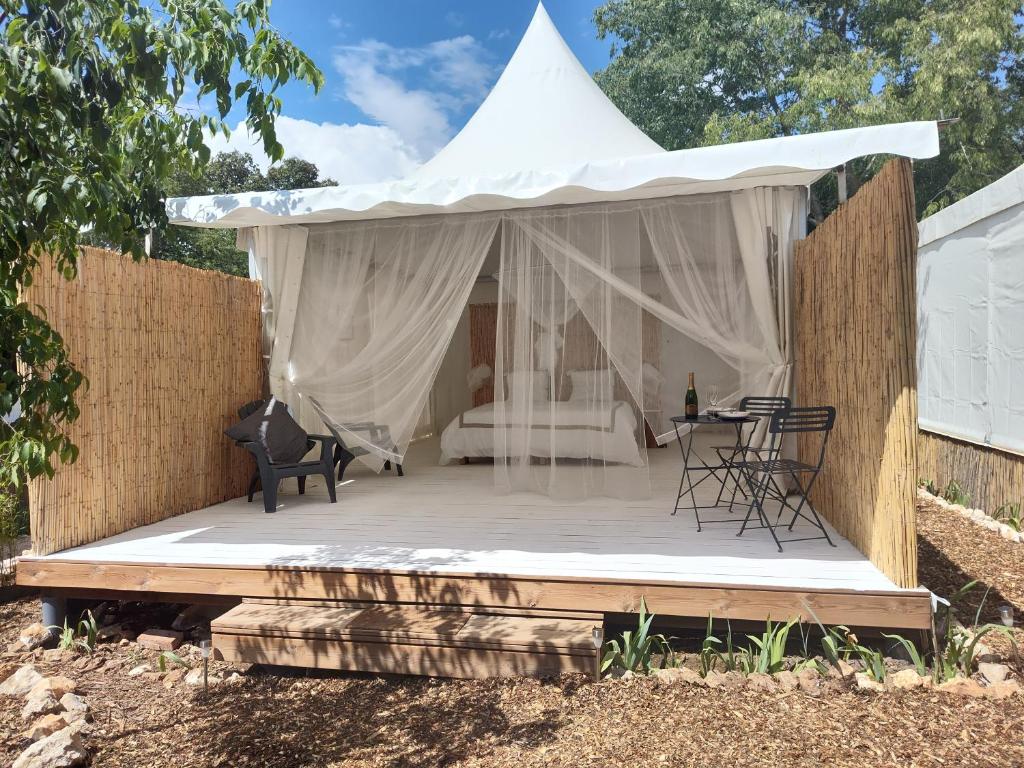 une tente avec une table et des chaises sur une terrasse dans l'établissement Glamping at Séraphin's, à Navacelles