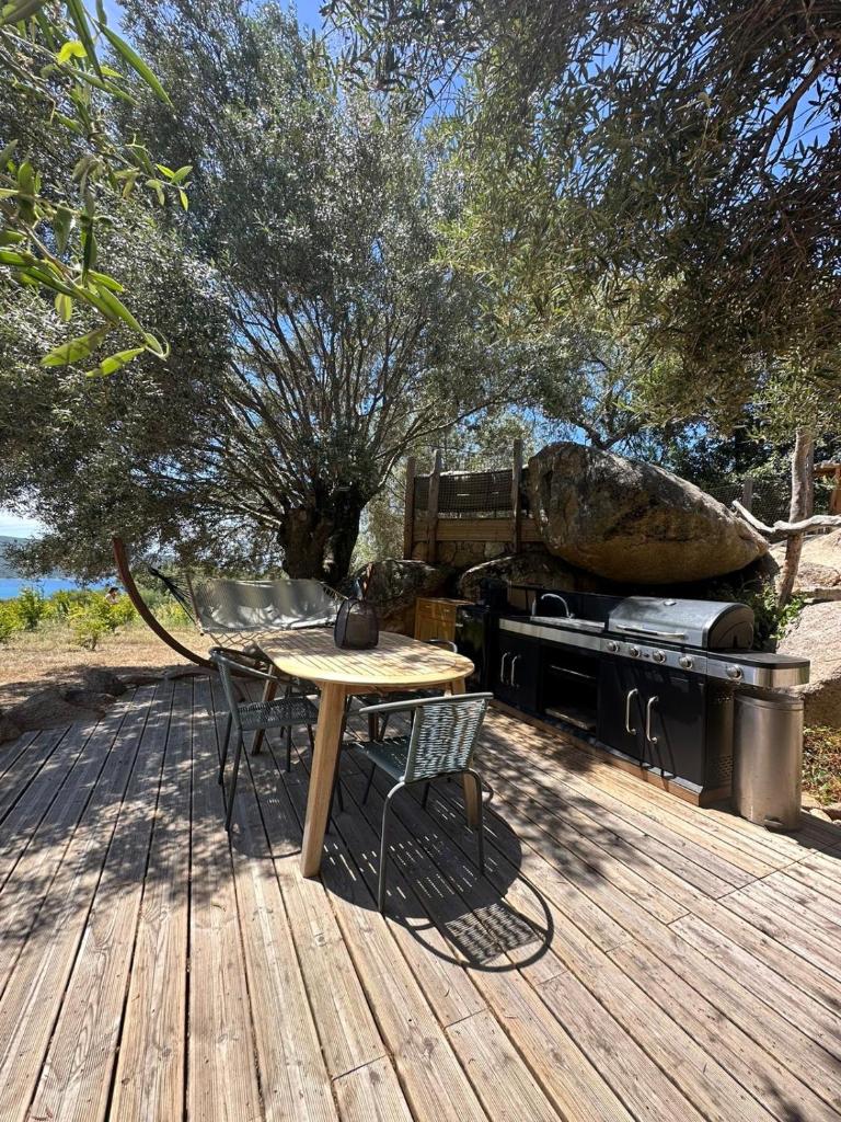 une table et des chaises sur une terrasse en bois avec un grill dans l'établissement A Malgrana - Tente lodge hébergement insolite, à Coti-Chiavari 19 autres photos