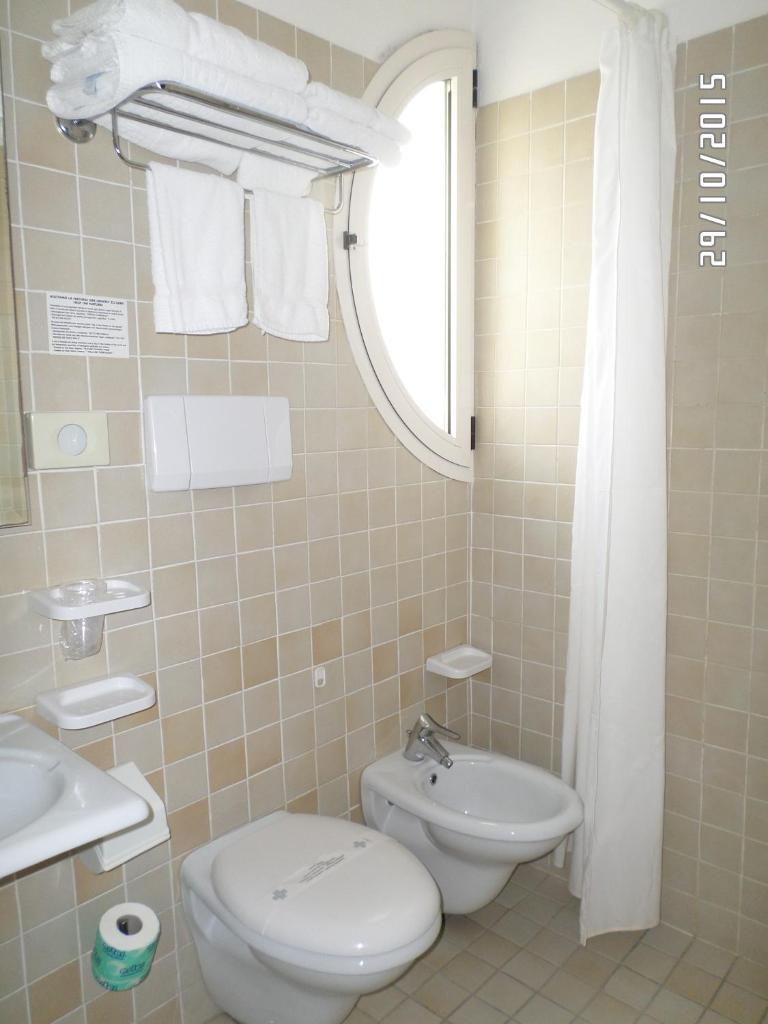 une salle de bain avec toilettes et lavabo dans l'établissement Hotel Houston, à Rimini