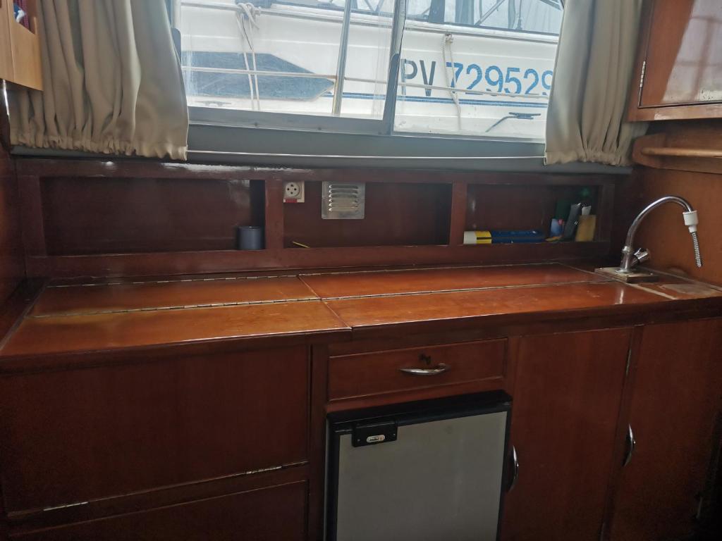 une cuisine avec un évier et une fenêtre dans l'établissement Petit yacht, au Barcarès