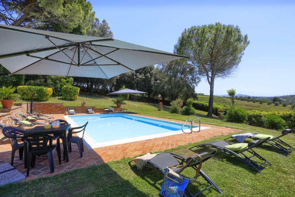 une piscine avec une table, des chaises et un parasol dans l'établissement Villa Orsini Peccioli - Villa storica ad uso esclusivo con piscina, à Peccioli