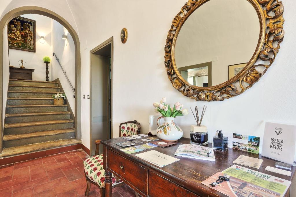 un miroir sur un mur au-dessus d'un bureau avec un miroir dans l'établissement Villa Orsini Peccioli - Villa storica ad uso esclusivo con piscina, à Peccioli