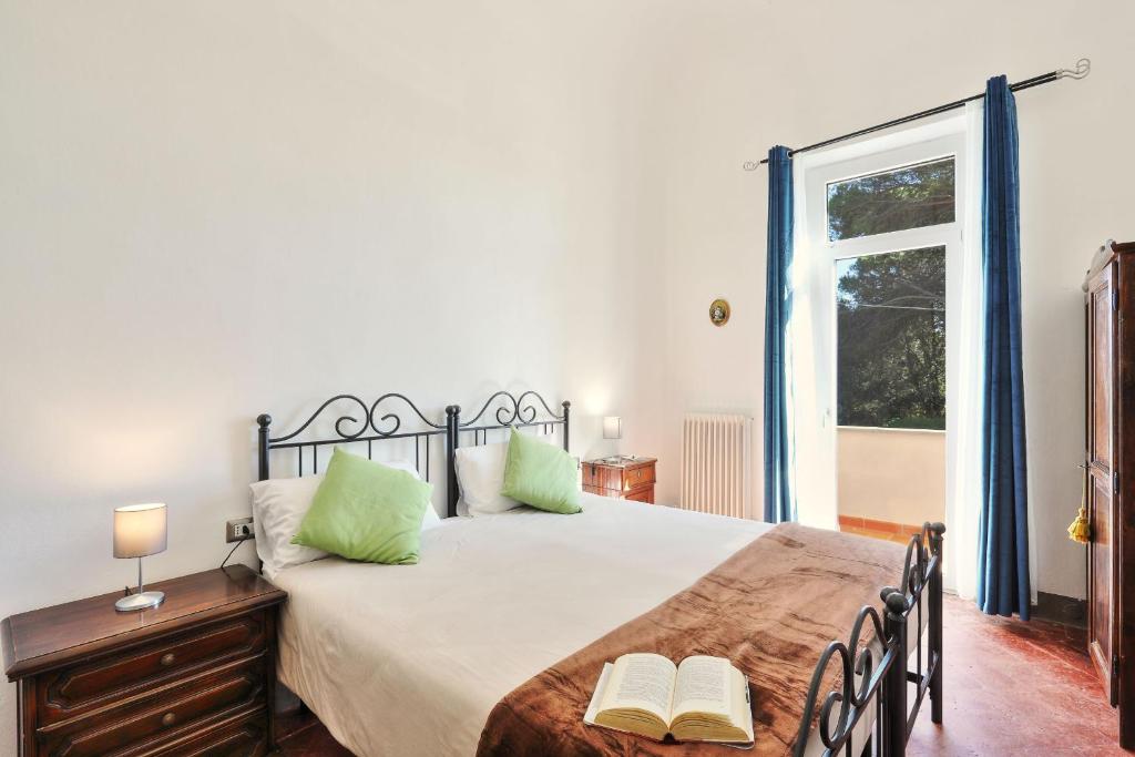 une chambre avec un lit avec des oreillers verts et une fenêtre dans l'établissement Villa Orsini Peccioli - Villa storica ad uso esclusivo con piscina, à Peccioli 75 autres photos