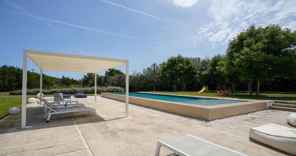 une piscine avec un pavillon dans l'établissement Odegos Villa Aira, à Torre dell'Orso