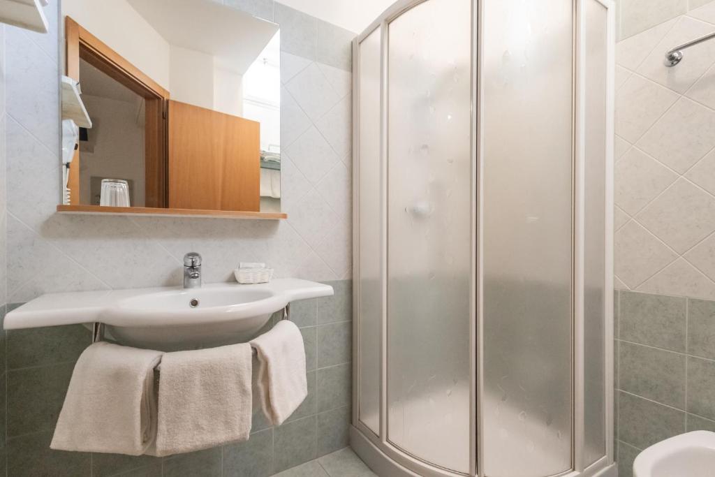 une salle de bain avec un lavabo et une douche dans l'établissement Hotel leonardo, à Cattolica