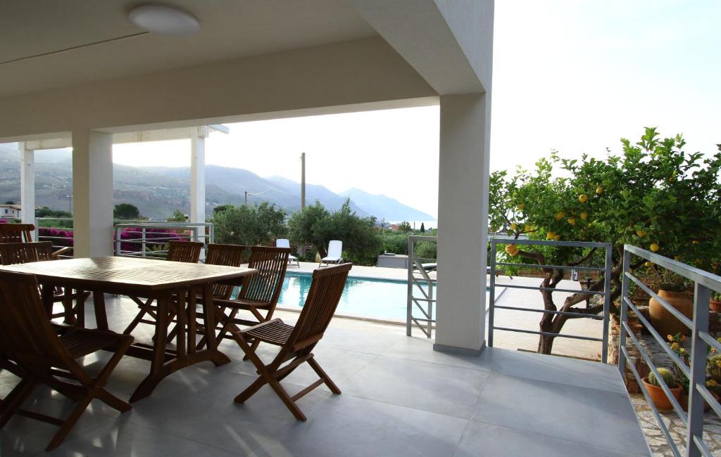 un patio avec une table et des chaises sur un balcon dans l'établissement villa grecale, à Castellammare del Golfo