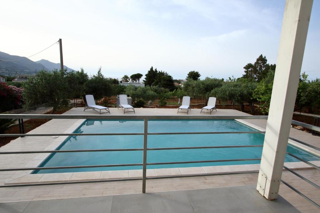 une piscine avec des chaises longues sur le toit dans l'établissement villa grecale, à Castellammare del Golfo