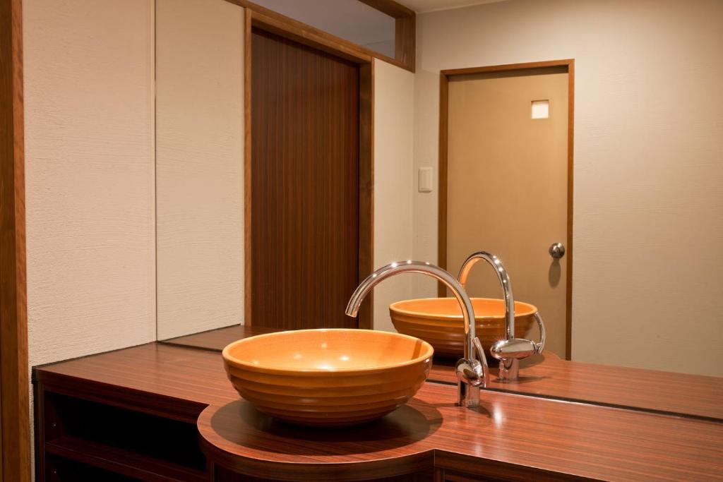 La salle de bains est pourvue d'un lavabo en bois. dans l'établissement Aura Tachibana, à Hakone