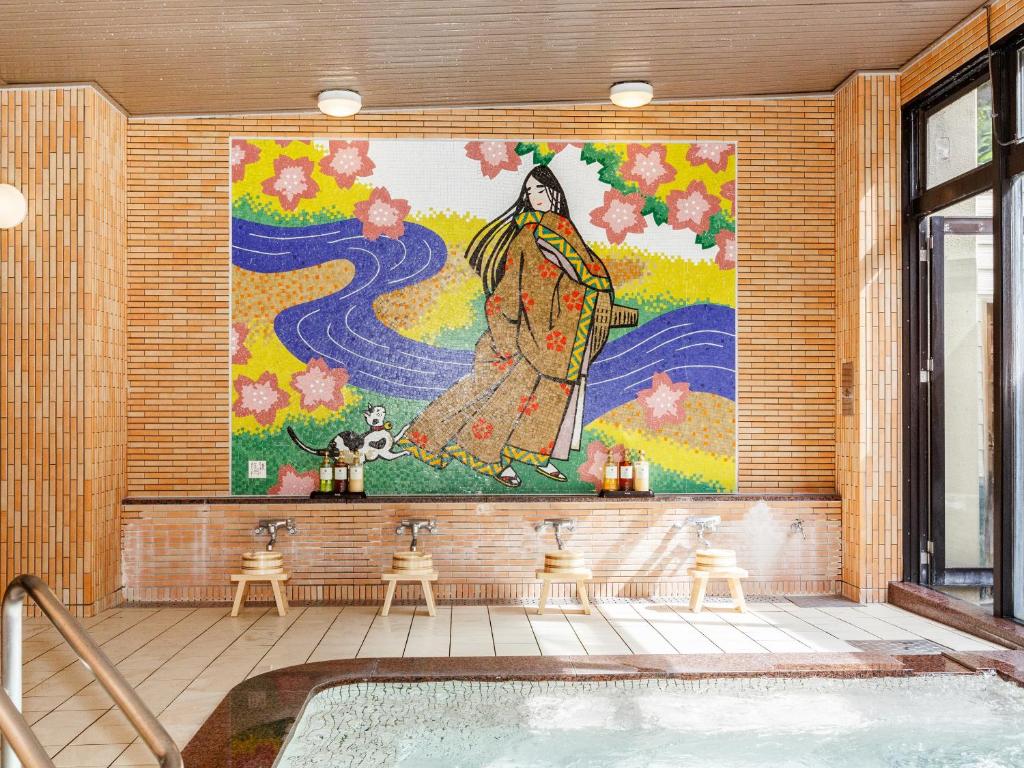 un grand tableau d'une femme sur un mur à côté d'une baignoire dans l'établissement 式部のやかた井筒屋, à Shirakawa-gō