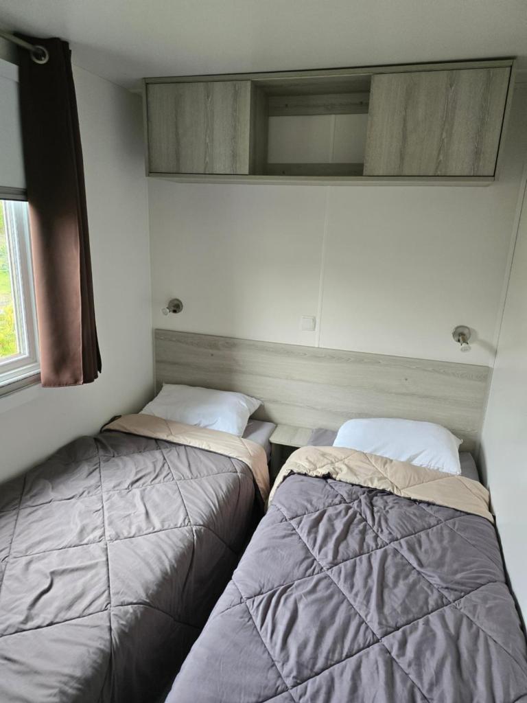 - deux lits dans l'angle d'une pièce dans l'établissement Mobil home camping les Viviers 8 personnes, à Lège-Cap-Ferret