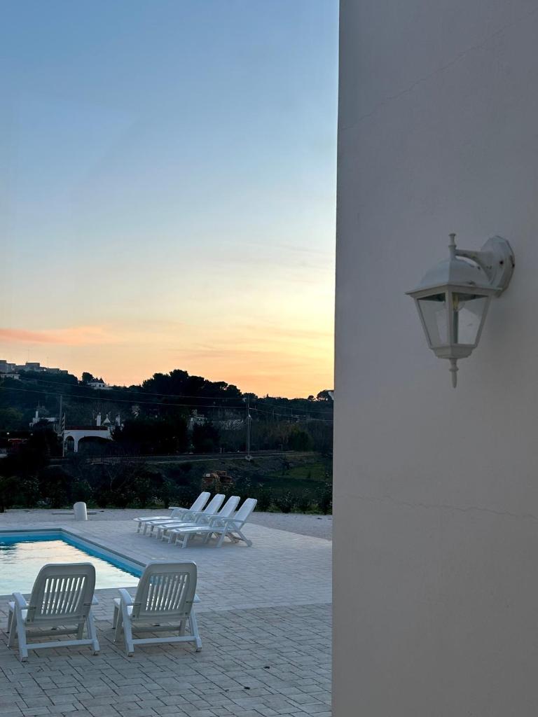 un groupe de chaises assises à côté d'une piscine dans l'établissement Lamia Itria, à Martina Franca
