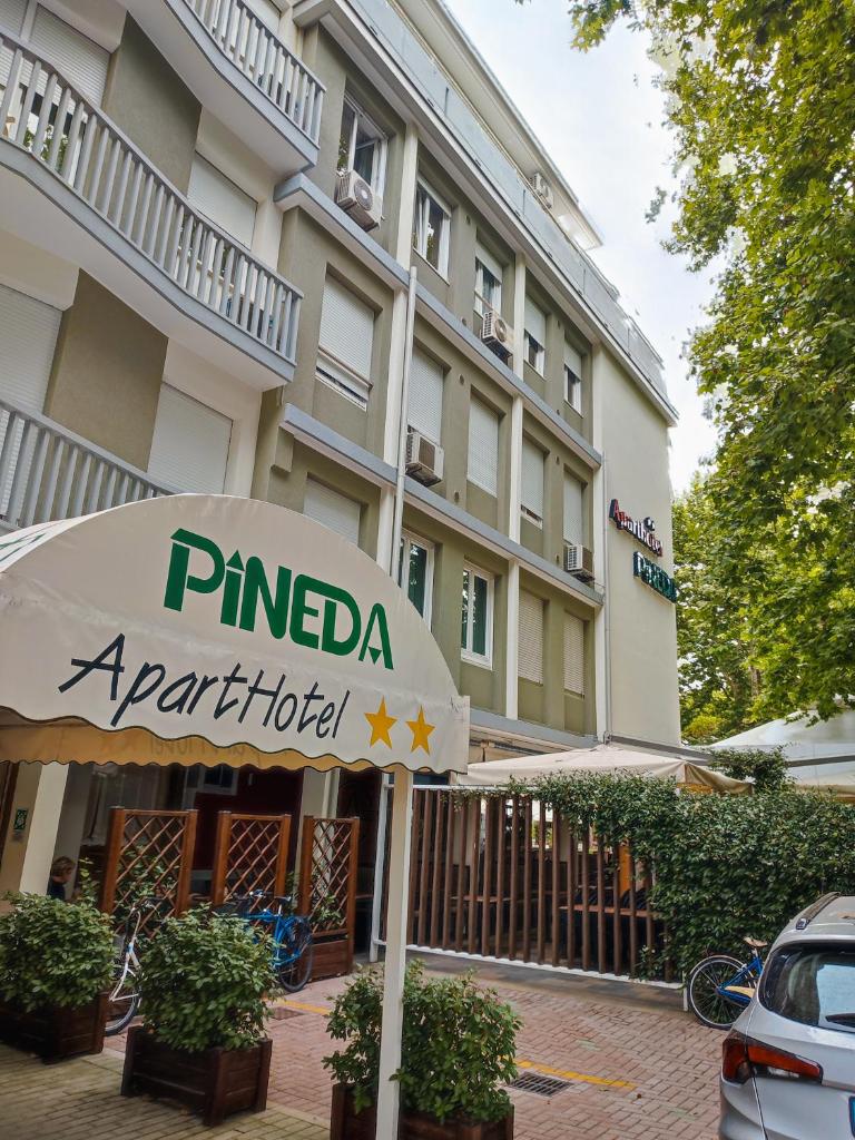 un panneau d'hôtel devant un bâtiment dans l'établissement Aparthotel Pineda, à Bibione