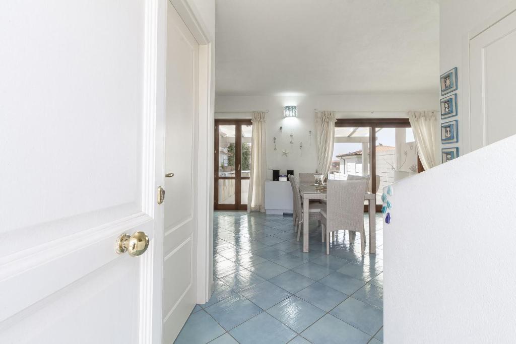 un couloir avec une table et une salle à manger dans l'établissement Villetta Marina Vista mare con piscina privata, à Stintino