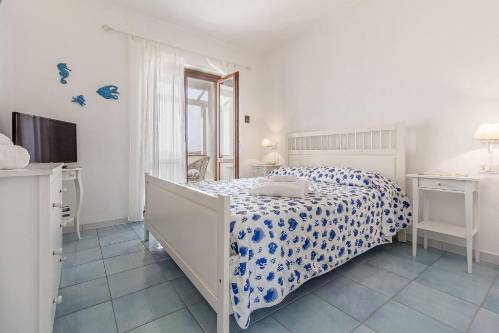 une chambre blanche avec un lit et une télévision dans l'établissement Villetta Marina Vista mare con piscina privata, à Stintino 43 autres photos