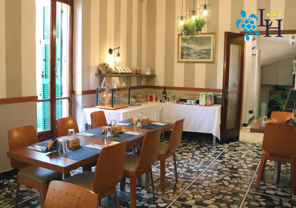 un restaurant avec deux tables et des chaises ainsi qu'un comptoir dans l'établissement Hotel Lora RDA Luxury, à Bordighera 41 autres photos