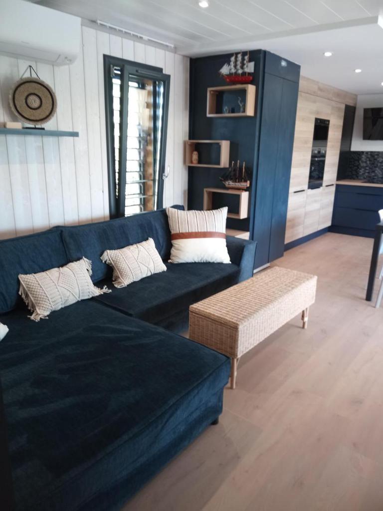 un salon avec un canapé bleu et une table dans l'établissement Charmant CHALET, à Pomérols