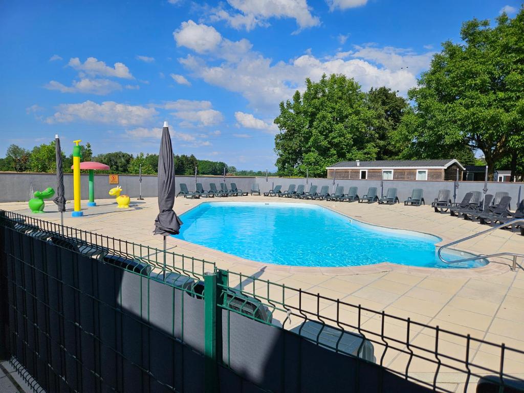une piscine avec des chaises et un parasol dans l'établissement Mobil-home climatisé (proximité EUROPA PARC), à Boofzheim 6 autres photos