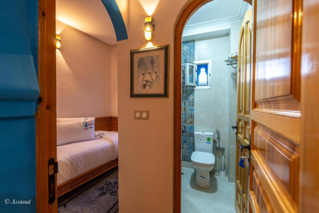 - une salle de bains avec toilettes et un lit dans une chambre dans l'établissement Dar Kisania, à Chefchaouen