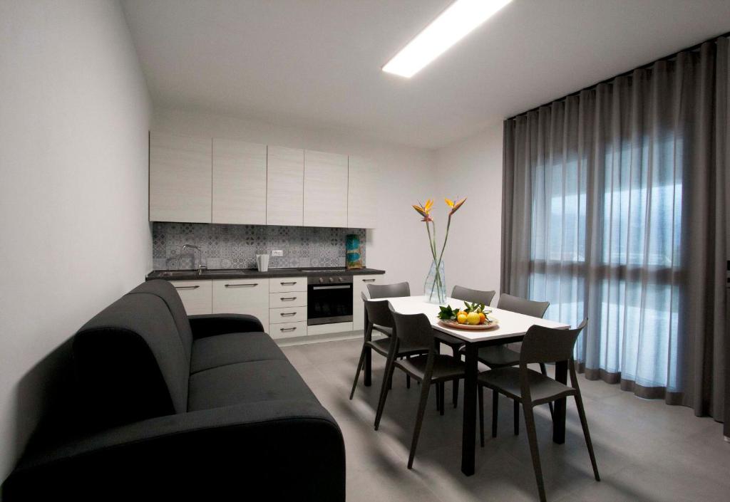 un salon avec un canapé et une table avec des chaises dans l'établissement villa grecale, à Castellammare del Golfo